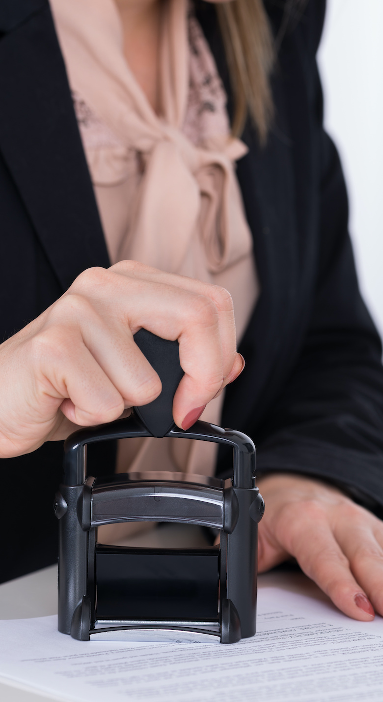 Businessperson Using Stamper On Document
